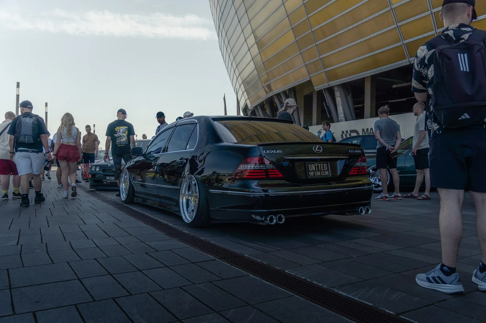 Black Lexus in front of the stadium among visitors