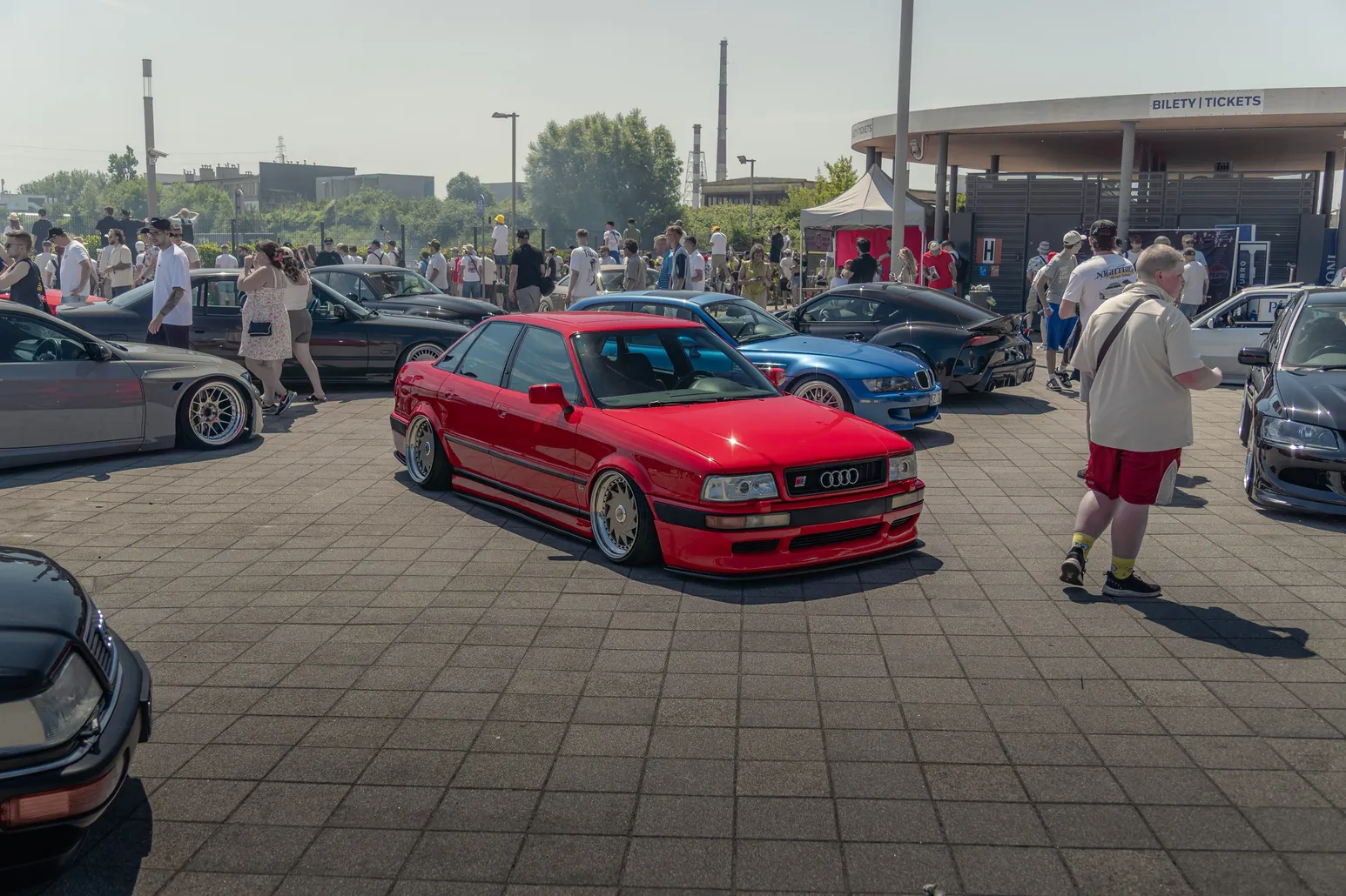 Red Audi 80 among visitors and cars