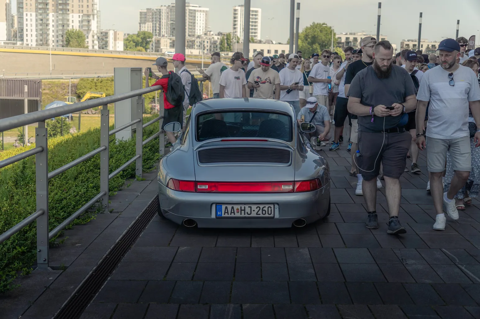 Silver Porsche 911 (993) from behind among visitors
