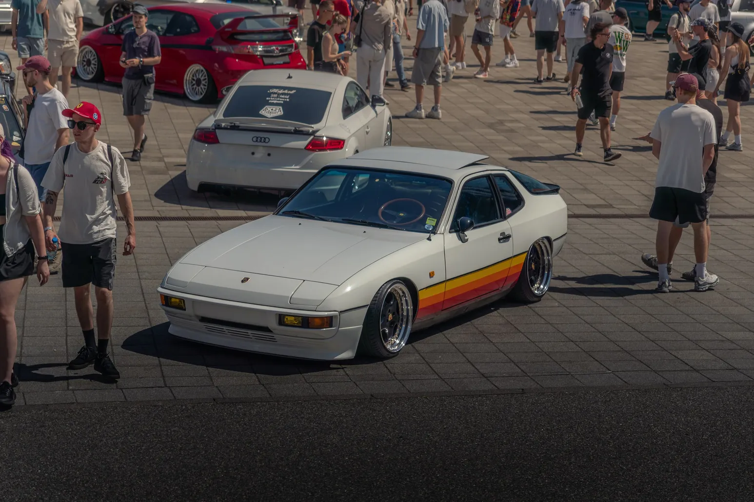 White Porsche 944 with retro stripes among visitors