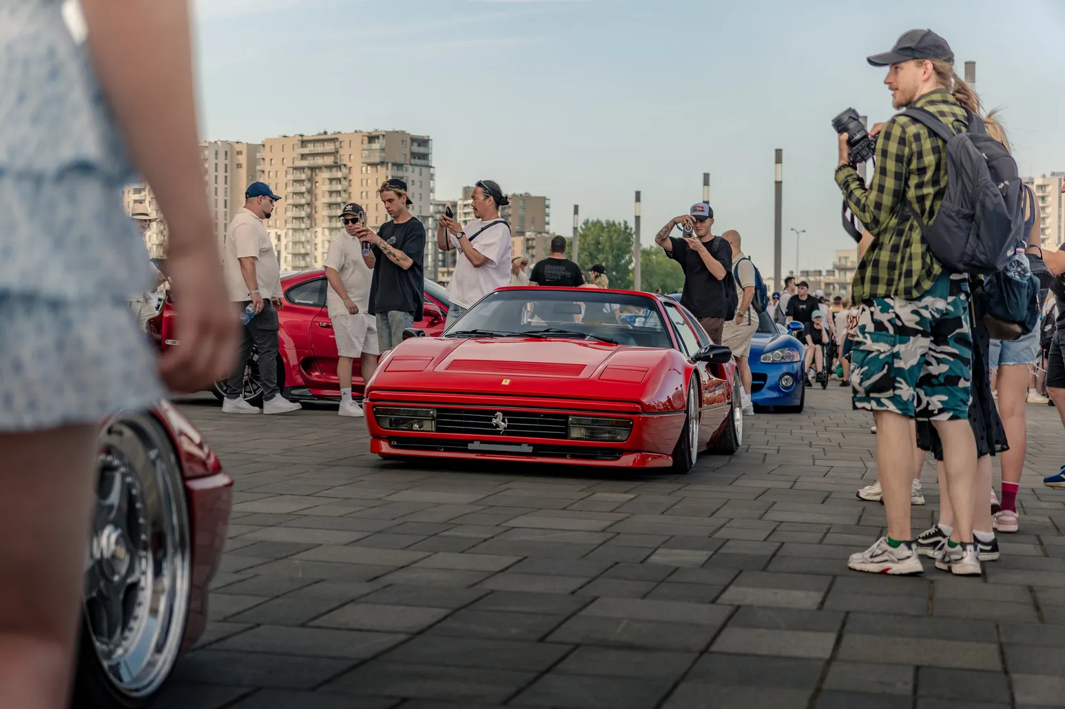 Red Ferrari between photographers and visitors