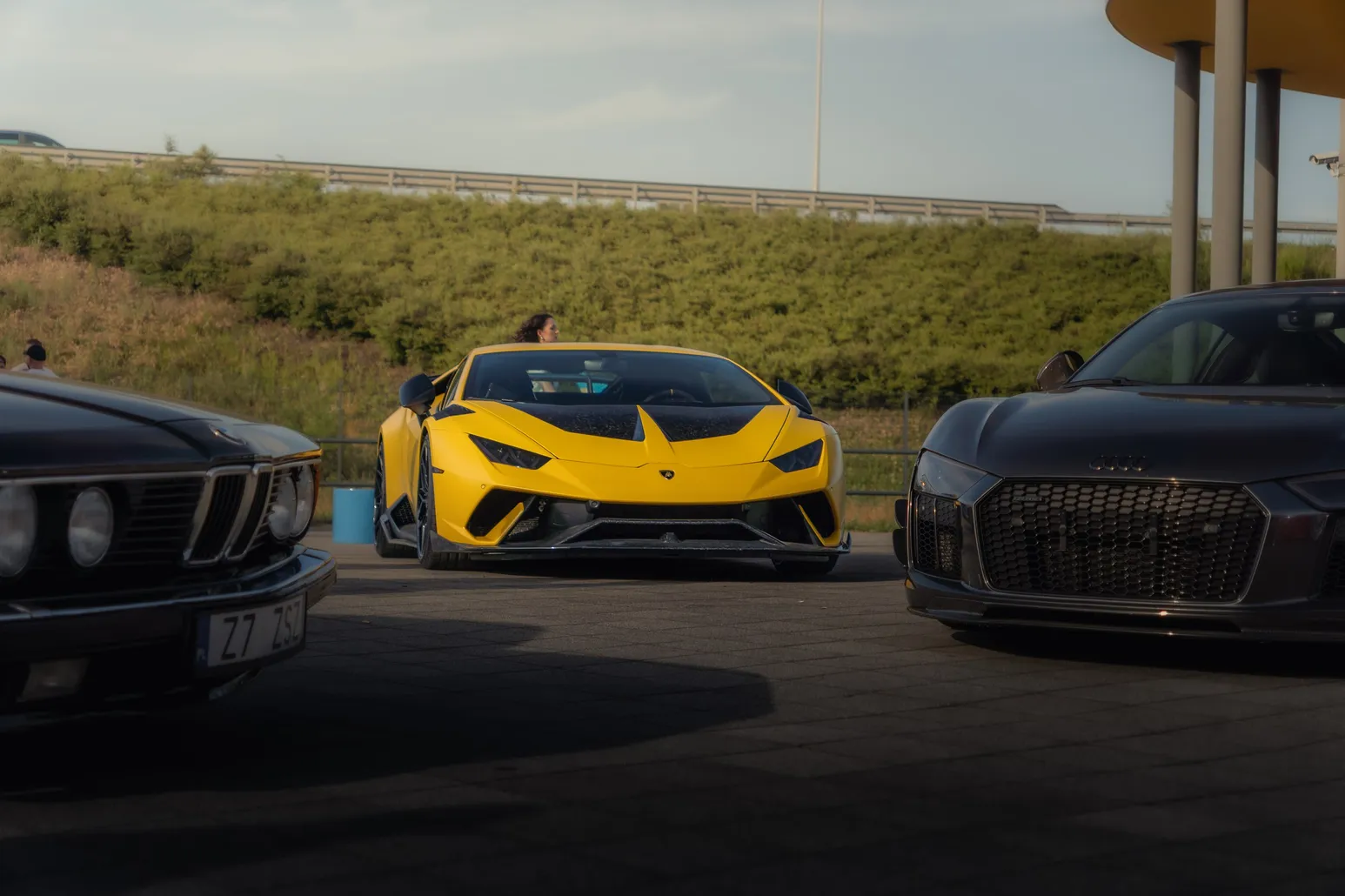 Yellow Lamborghini Huracán in front of a grassy slope