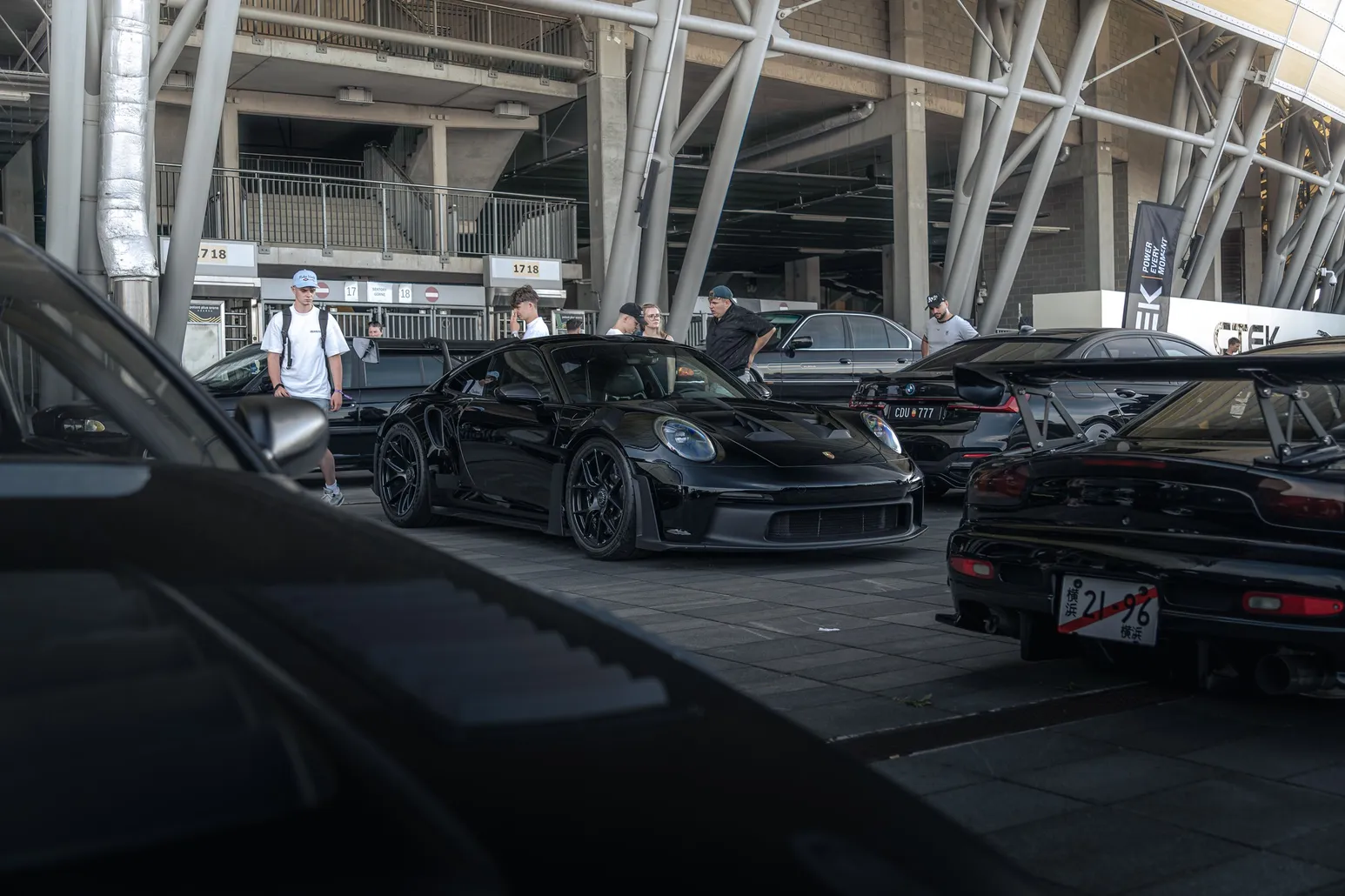 Black Porsche and classics under the stadium canopy