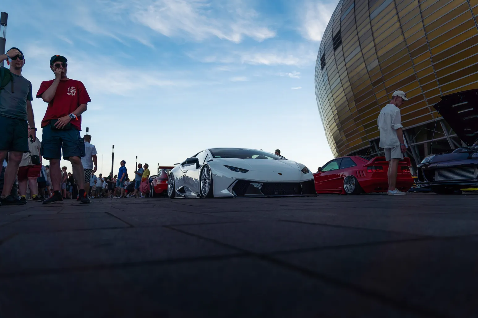 White Lamborghini and visitors in front of the stadium