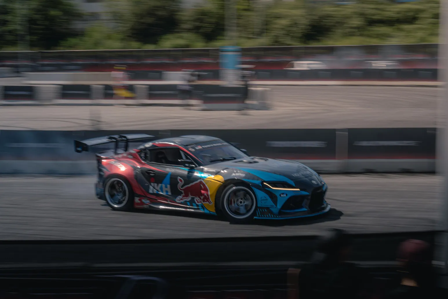 Toyota GR Supra with colourful livery drifting in a panning shot