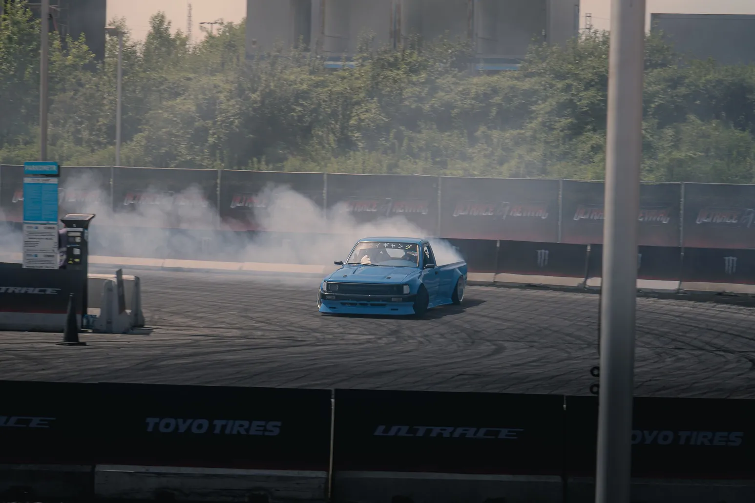 Light blue drift car with smoke on the course