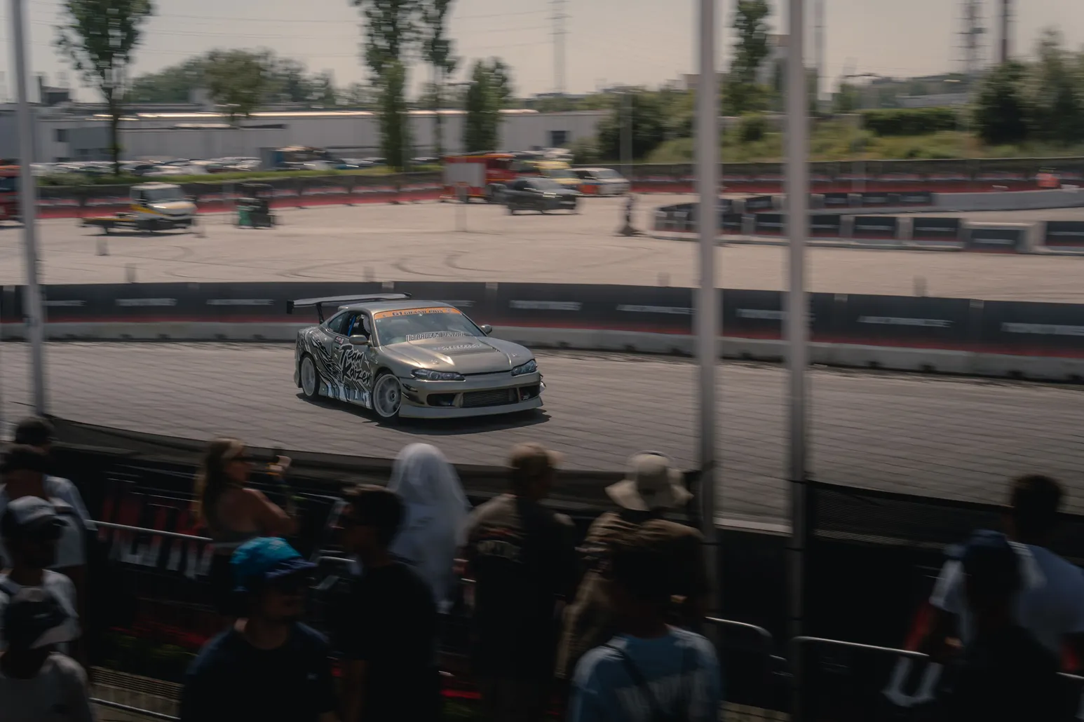 Silver drift car beyond the spectators