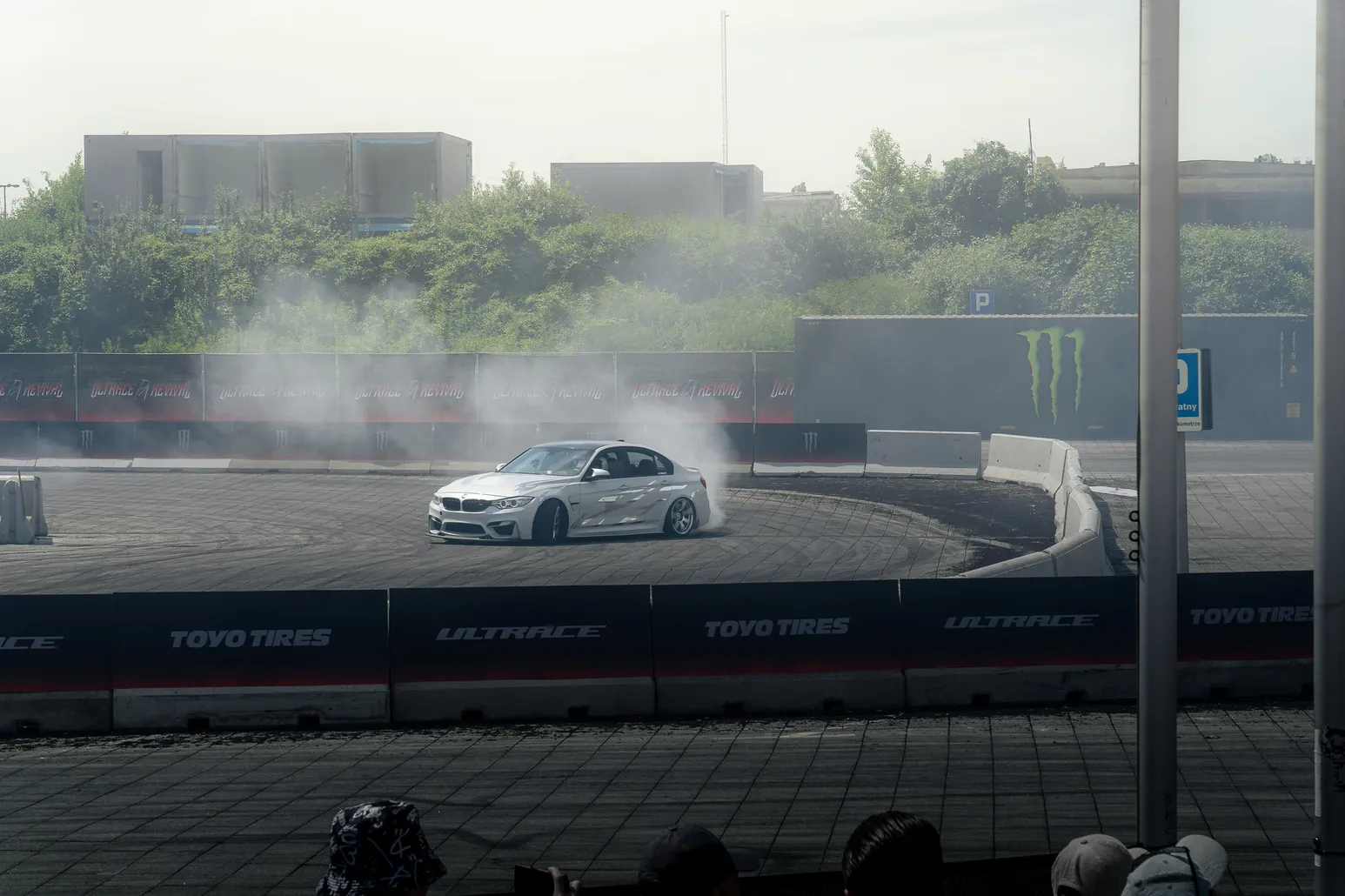 White BMW drifting through a corner with smoke