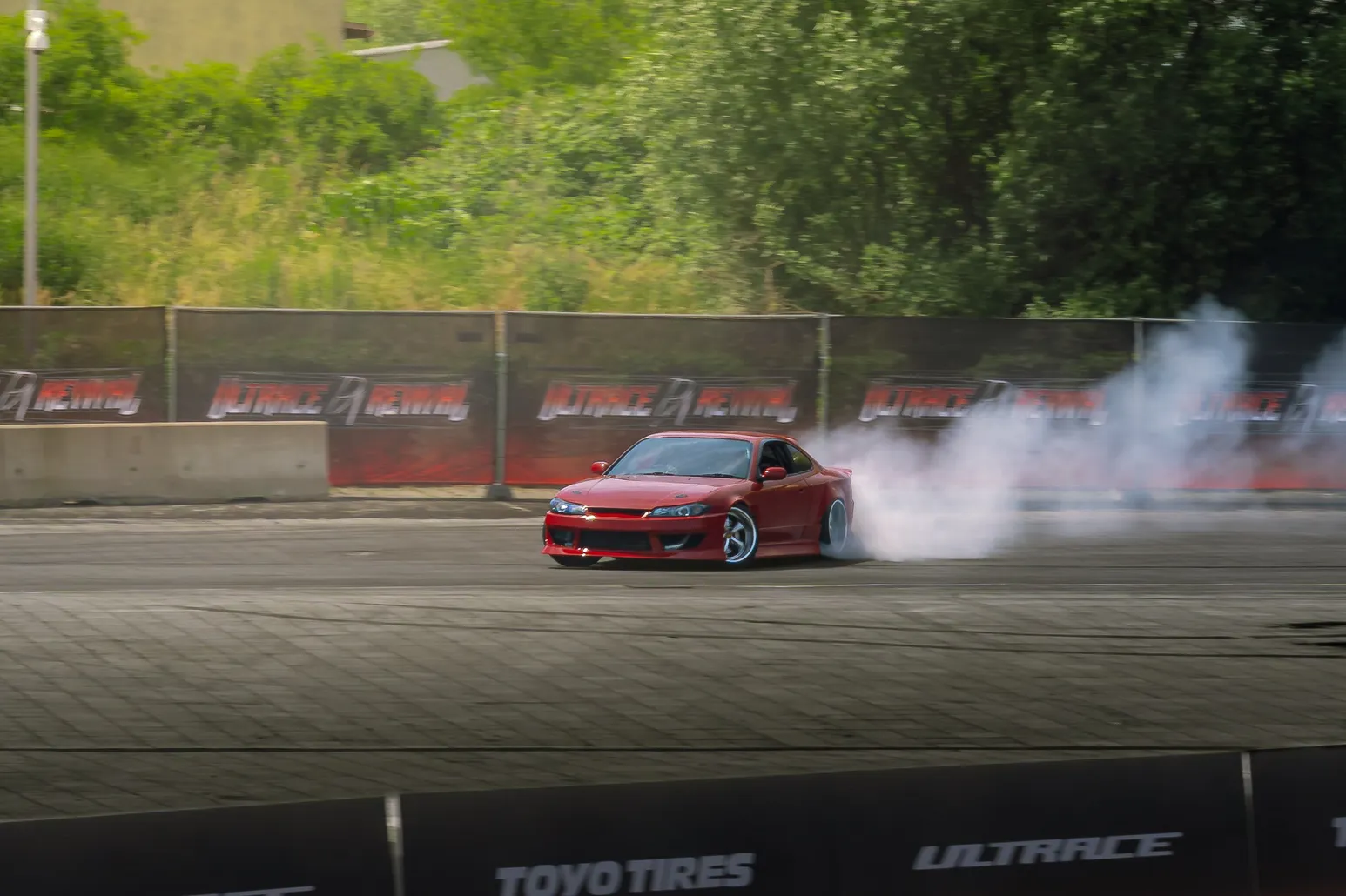 Red Nissan Silvia drifting with a smoke trail