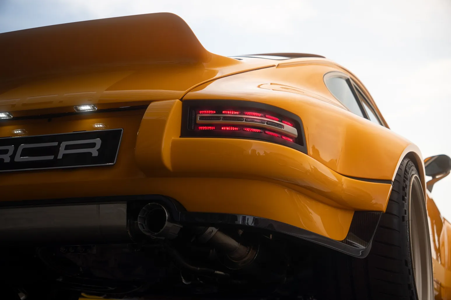 Rear of an orange Porsche in detail