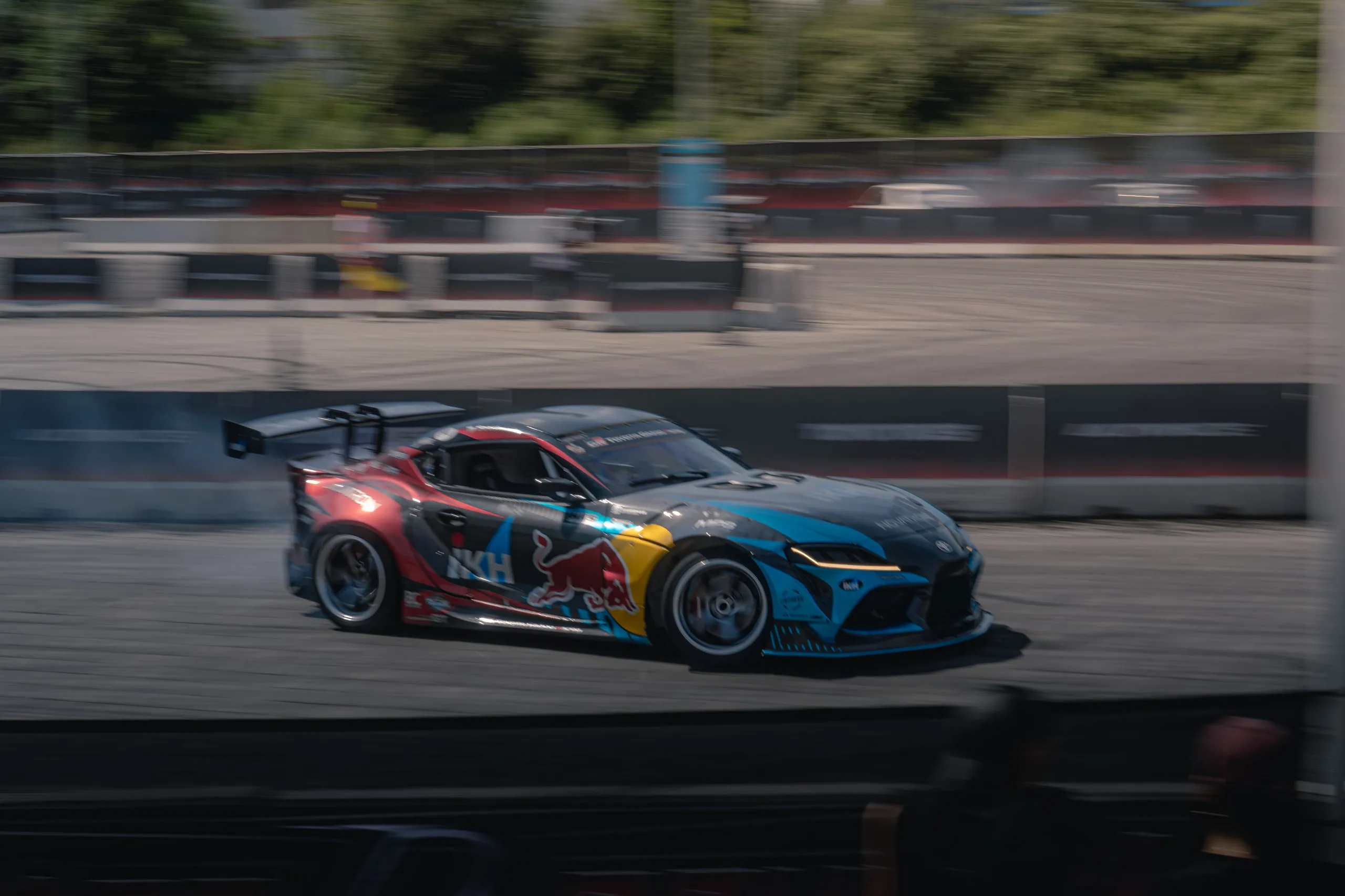 Toyota GR Supra with colourful livery drifting in a panning shot
