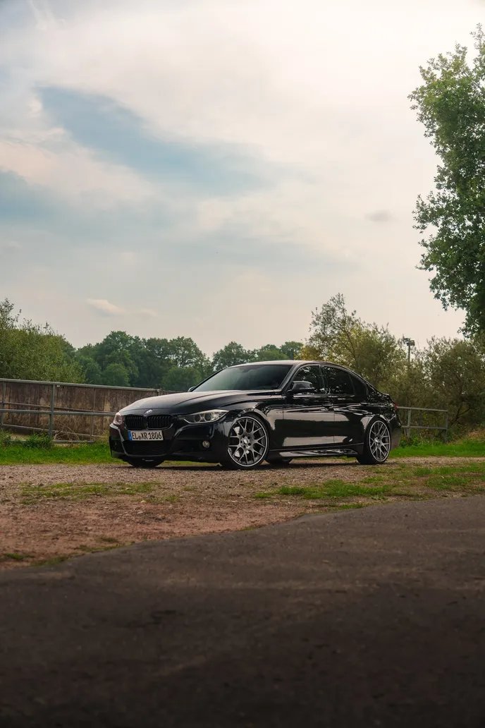 Black BMW F30 small in frame under a big sky