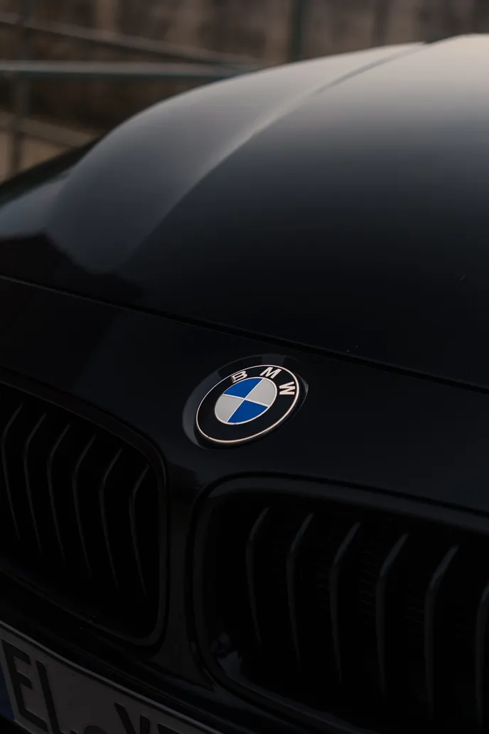 BMW badge on the black bonnet, portrait detail