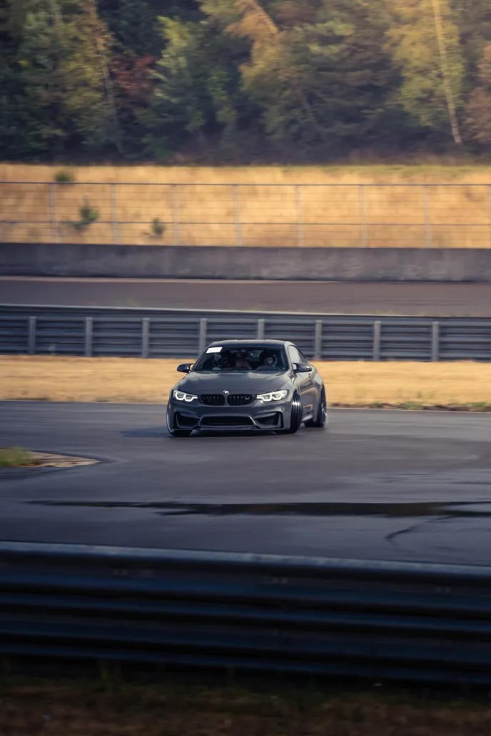 Grey BMW on the far side of the wet track