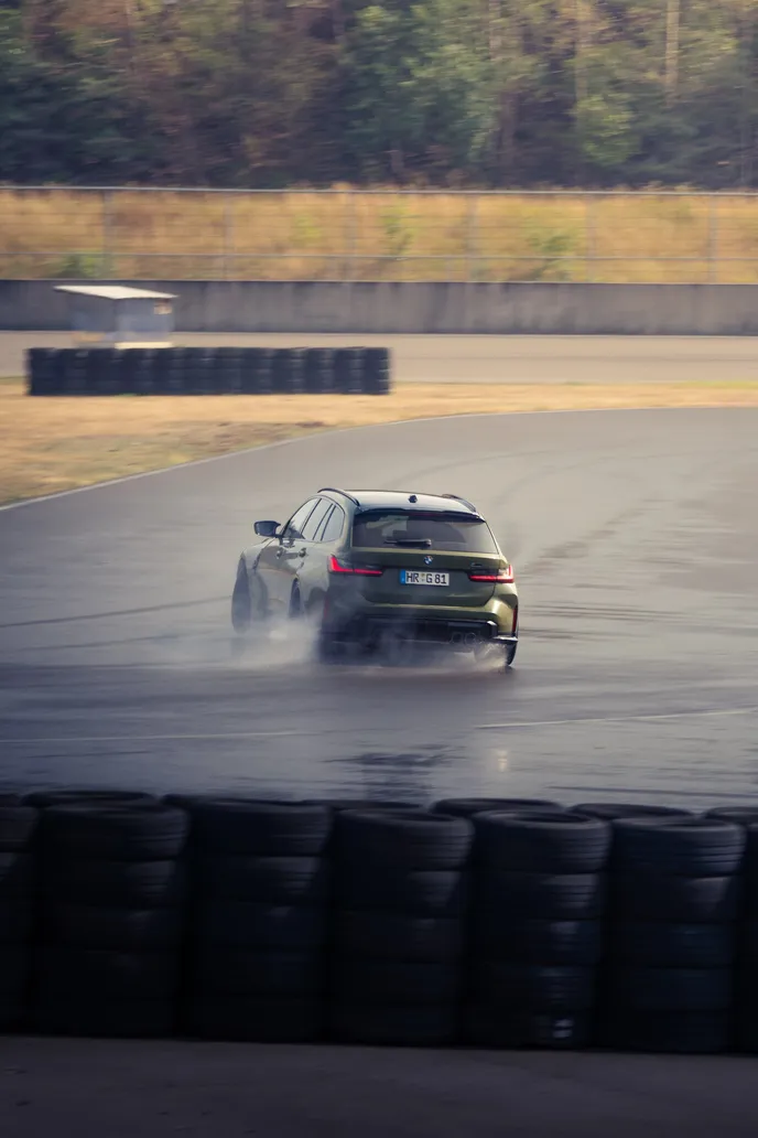 BMW drifting through spray on a wet corner