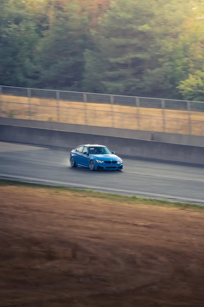 Blue BMW M2 on the straight in a portrait panning shot