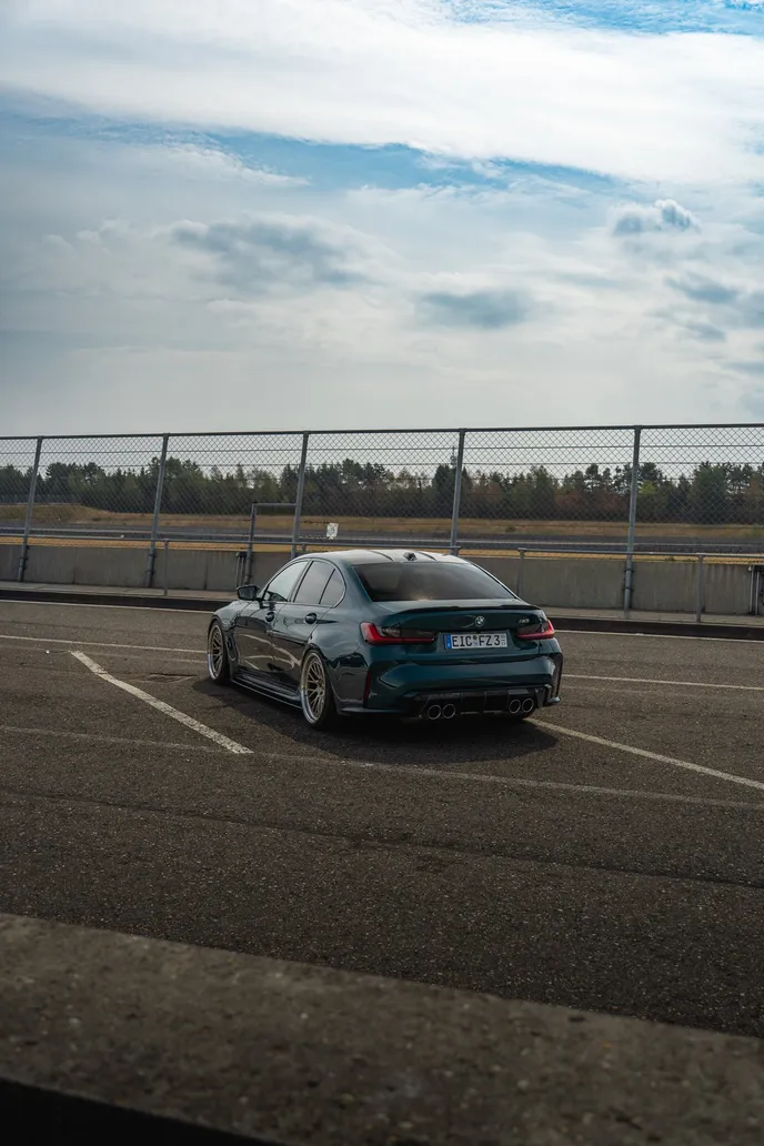 Green BMW M3 in the paddock, portrait format