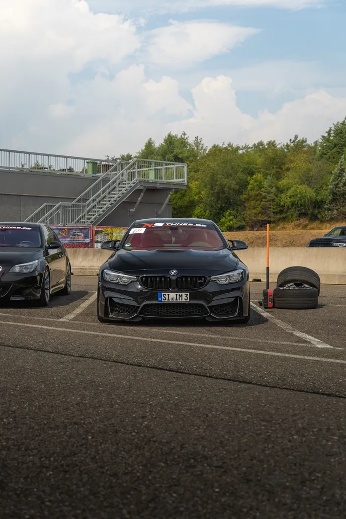 Black BMWs in the paddock below the grandstand