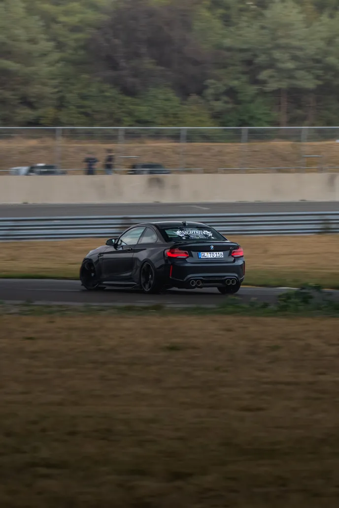 Black BMW M2 sliding in the distance, portrait format