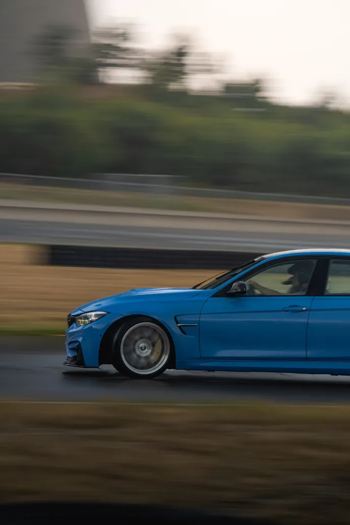 Blue BMW M3 side-on panning shot with motion blur