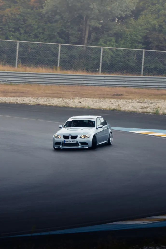 White BMW drifting through the corner, portrait format