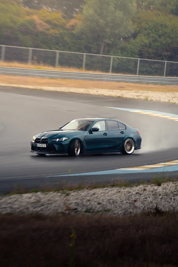 Green BMW M3 sliding out of the corner