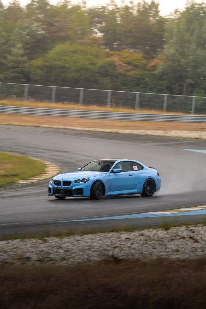 Light blue BMW M2 drifting through the bend