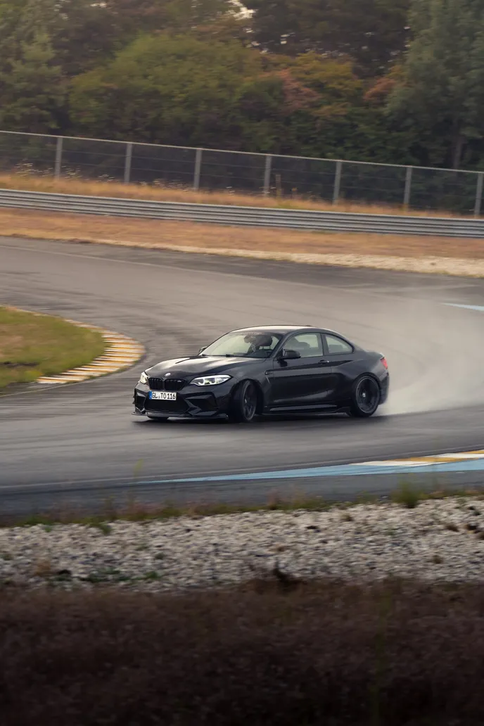 Black BMW drifting over the kerb, portrait format