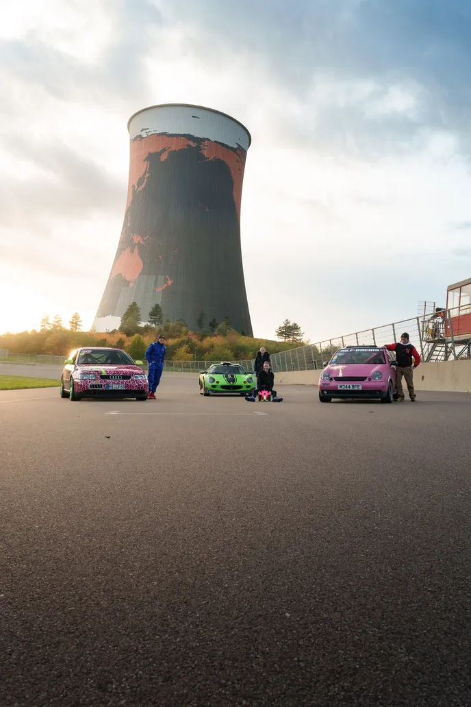 Cooling tower in portrait format with the three team cars below