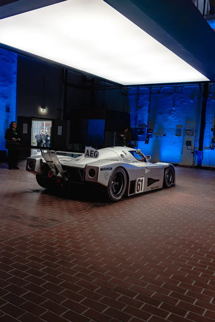 Group C race car from behind against blue light, portrait format