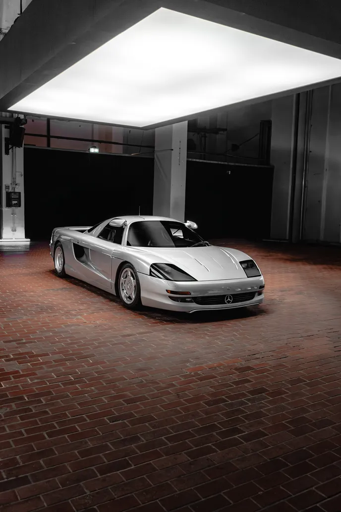 Silver supercar under the light panel, portrait format