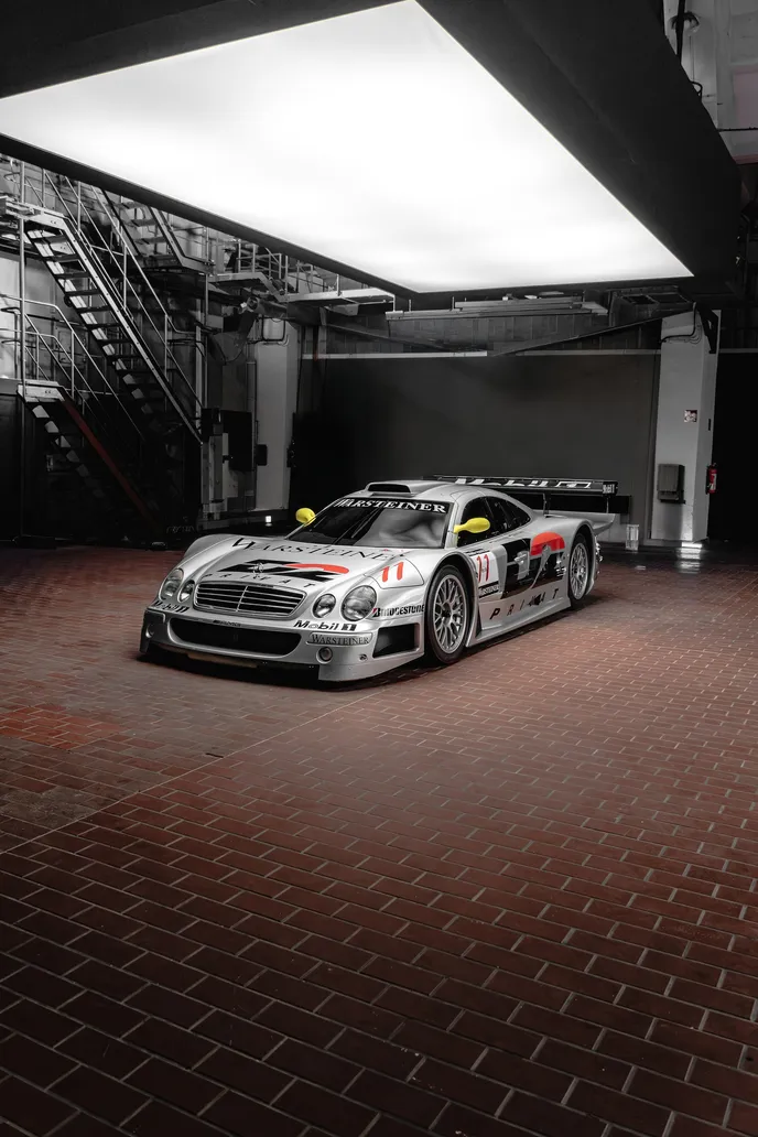 Silver Mercedes race car under the light ceiling, portrait format