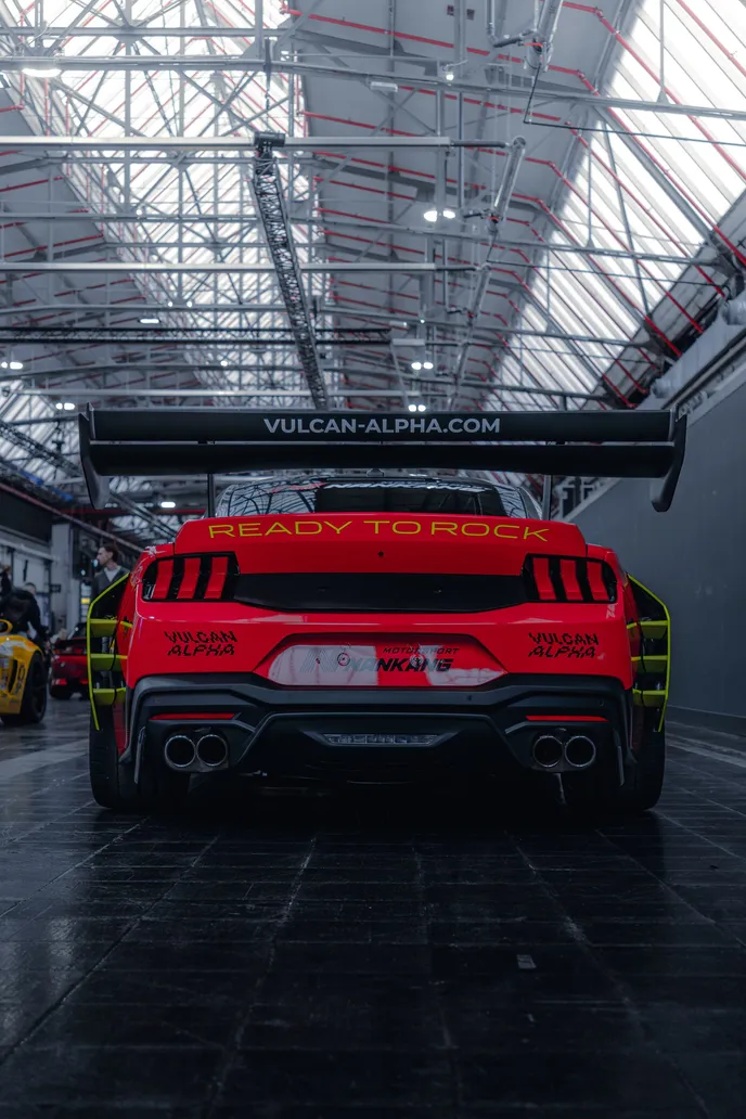 Red race car from behind under the hall roof, portrait format