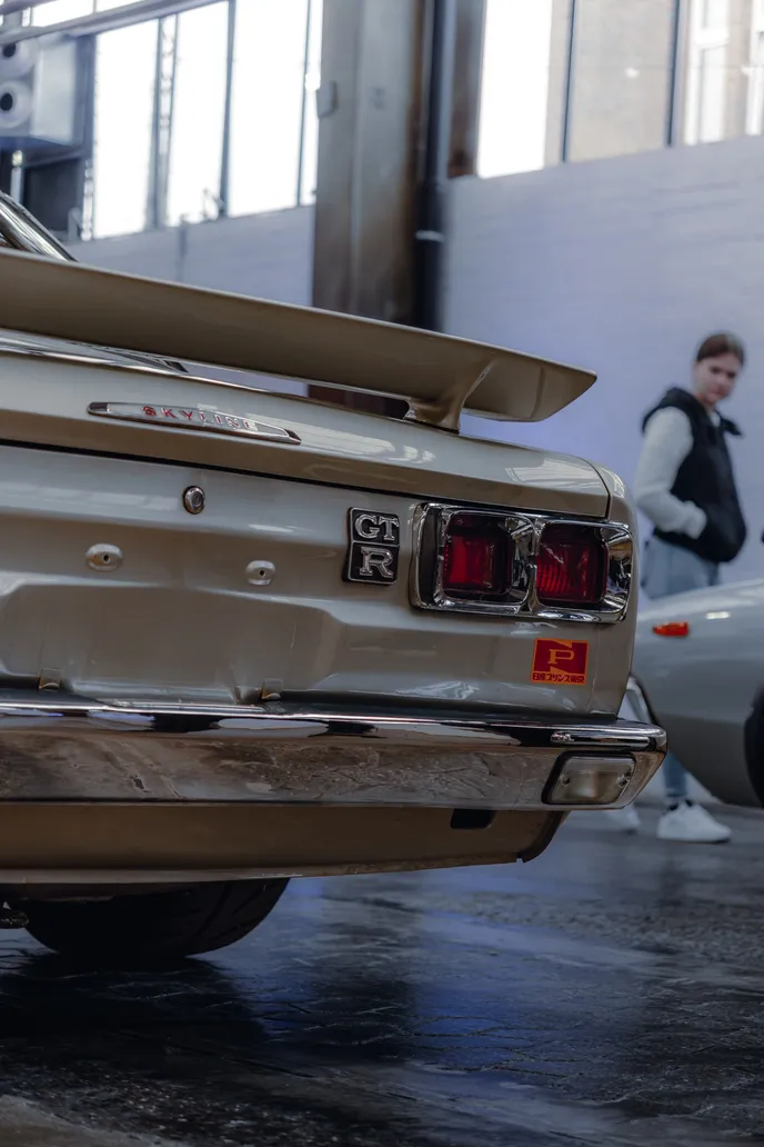 Rear of a classic Japanese car with round tail lights, portrait format