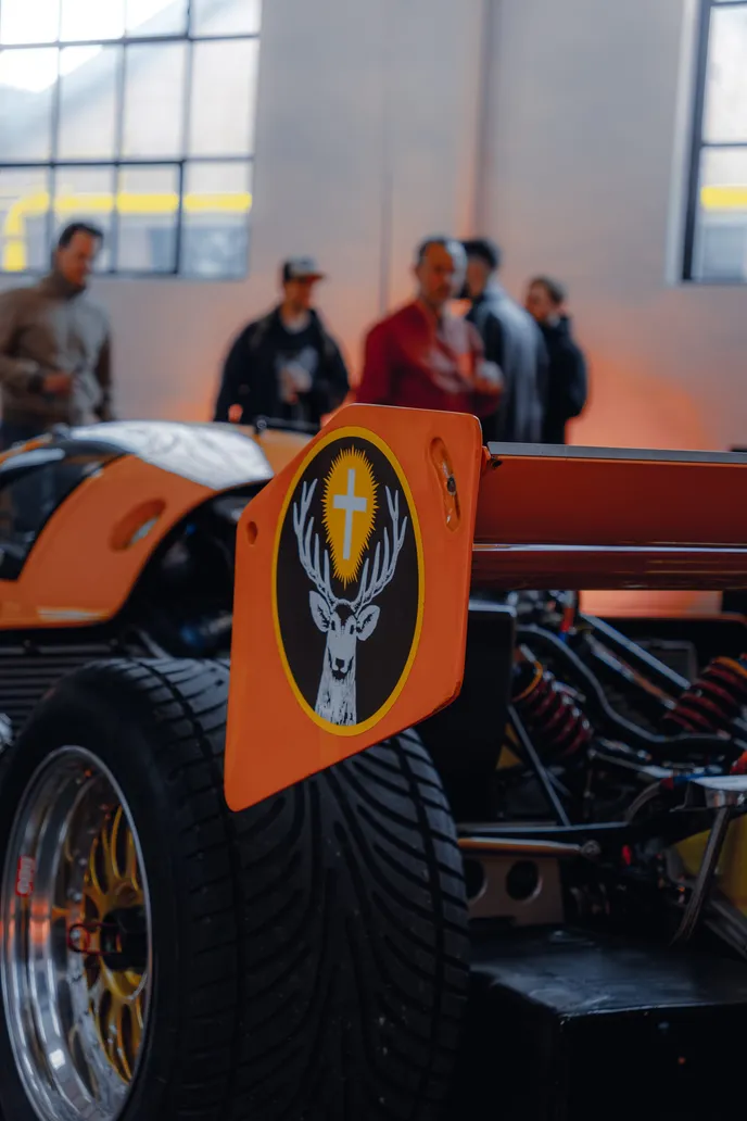 Off-road vehicle with an orange emblem and visitors, portrait format