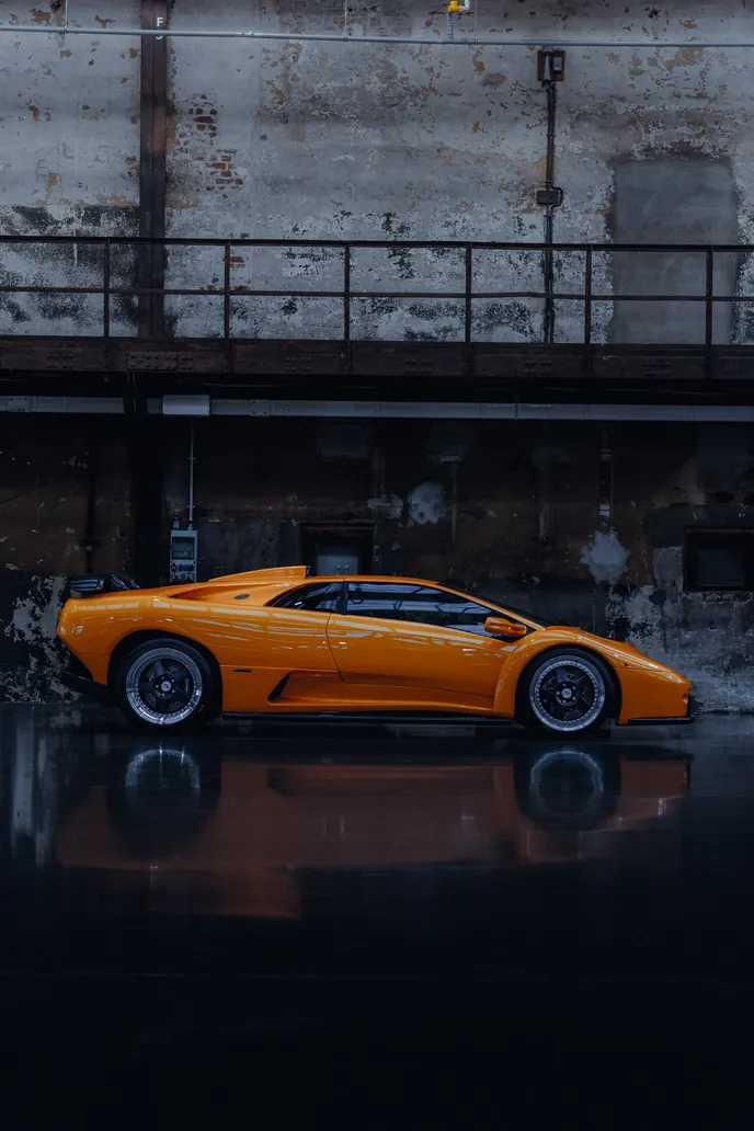 Orange Lamborghini Diablo reflected in the hall floor, portrait format