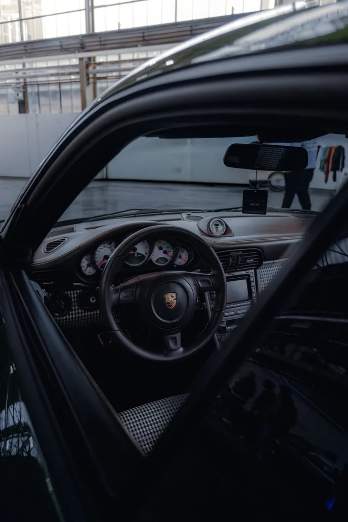 View through the open door into a Porsche cockpit, portrait format
