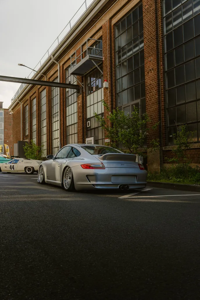 Silver Porsche 911 GT3 in front of the brick hall, portrait format