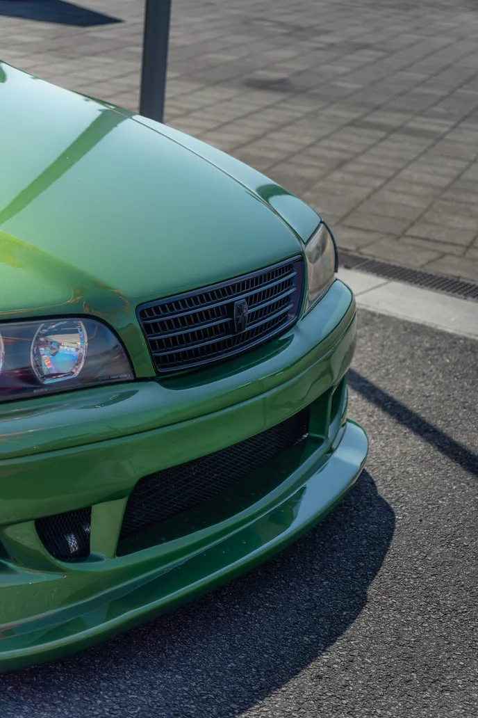 Front of the green Toyota Chaser in close-up, portrait format